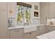 Close up of a bright kitchen featuring a farmhouse sink, marble countertops, and custom cabinets at 2187 Saint James Dr, Charleston, SC 29412