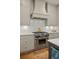 Modern kitchen features stainless steel stove, marble countertops, custom cabinetry, and an orange tea kettle at 2187 Saint James Dr, Charleston, SC 29412
