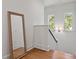 Bright upstairs landing with wood floors, natural light, and a leaning mirror at 2187 Saint James Dr, Charleston, SC 29412