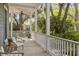 Relaxing porch with ceiling fan, white railings, and comfortable seating overlooking a lush landscape at 2187 Saint James Dr, Charleston, SC 29412