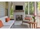 Outdoor screened in porch with fireplace, tv and plush outdoor seating at 2187 Saint James Dr, Charleston, SC 29412