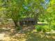 Aerial view of a brick home surrounded by mature trees, showcasing its quiet and secluded setting at 2234 River Rd, Johns Island, SC 29455