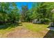 Expansive backyard featuring lush lawn, mature trees, and an outbuilding at 2234 River Rd, Johns Island, SC 29455