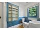 Bathroom with built-in shelving, toilet, small sink, and a window offering natural light at 2234 River Rd, Johns Island, SC 29455