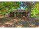 Quaint brick home with a front porch nestled among mature shade trees at 2234 River Rd, Johns Island, SC 29455