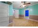 Corner room with seafoam green walls, light wood floor, ceiling fan, and white trim in an older home at 2234 River Rd, Johns Island, SC 29455