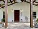 Welcoming front porch with seating and dark wood support beams at 224 Reeves St, Reevesville, SC 29471