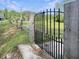Rustic wooden fence with an ornate wrought-iron gate leading to the property at 224 Reeves St, Reevesville, SC 29471