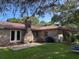 Brick home exterior features a patio, red metal roof, and spacious, green backyard at 2331 Furman Dr, Charleston, SC 29414