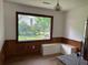 Sunlit dining area boasts views of the landscaped yard, white bench, and wood paneling at 2331 Furman Dr, Charleston, SC 29414