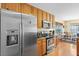 Modern kitchen boasting stainless steel refrigerator, wooden cabinets, and views into the adjacent dining area at 236 Everwood Ct, Moncks Corner, SC 29461
