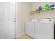 Functional laundry room with a washer, dryer, and storage shelving at 236 Everwood Ct, Moncks Corner, SC 29461