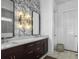 Well-lit bathroom vanity with double sinks, stylish wallpaper, and modern fixtures near a door at 2524 Josiah St, Charleston, SC 29492