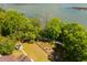 Aerial view of a cozy backyard sitting area with a fireplace surrounded by lush greenery near the water at 2538 Helmsman Rd, Johns Island, SC 29455