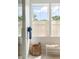 Bright bathroom showcasing a window with woven shades, a woven basket, and a bench at 2538 Helmsman Rd, Johns Island, SC 29455