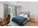 Bedroom with blue bedspread, wooden desk chair, and natural light from window at 2538 Helmsman Rd, Johns Island, SC 29455