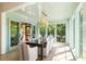 Bright dining room boasts a dark wood table and chairs, enhanced by natural light and a modern chandelier at 2538 Helmsman Rd, Johns Island, SC 29455