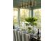 Elegant dining room features natural light, light-green walls, stylish decor and table settings at 2538 Helmsman Rd, Johns Island, SC 29455