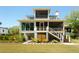 Stately three-story home with screened porches, lush landscaping, and a manicured lawn at 2538 Helmsman Rd, Johns Island, SC 29455