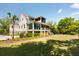 Stunning home featuring screened-in porches, surrounded by a lush, green lawn and mature trees at 2538 Helmsman Rd, Johns Island, SC 29455