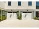 Attached two-car garage featuring white doors and an exterior with horizontal siding and climbing vines at 2538 Helmsman Rd, Johns Island, SC 29455