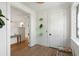Bright hallway featuring hardwood floors, decorative leaf art, and a rattan bench, leading to other rooms at 2538 Helmsman Rd, Johns Island, SC 29455