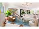 Spacious living room with modern light fixture, white sofas and multiple wicker chairs at 2538 Helmsman Rd, Johns Island, SC 29455