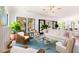 Spacious living room with modern light fixture, white sofas and multiple wicker chairs at 2538 Helmsman Rd, Johns Island, SC 29455