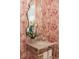 Close-up of powder room sink with red-and-white palm wallpaper and an orchid at 2538 Helmsman Rd, Johns Island, SC 29455