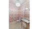 Powder room with red-and-white palm wallpaper, chandelier, and silver fixtures at 2538 Helmsman Rd, Johns Island, SC 29455