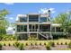 Elegant rear exterior with screened porches, ample windows, and lush landscaping at 2538 Helmsman Rd, Johns Island, SC 29455