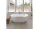 Bright bathroom features a standalone soaking tub with fixtures and a window with blinds at 2538 Helmsman Rd, Johns Island, SC 29455