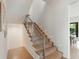 Bright staircase featuring hardwood steps, glass railings, and modern lighting for a clean, contemporary look at 2538 Helmsman Rd, Johns Island, SC 29455