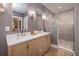 Modern bathroom with dual sinks, quartz countertop, sleek fixtures, and glass-enclosed walk-in shower at 301 Beaufort St, Summerville, SC 29483
