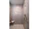 Modern bathroom featuring gray tiled walls, mosaic tile floor, and a gold finished shower head and hardware at 301 Beaufort St, Summerville, SC 29483