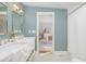 Stylish bathroom showcasing a double vanity, square mirrors, modern lighting, and tranquil blue-green walls at 301 Beaufort St, Summerville, SC 29483