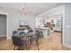 Bright dining area next to a modern kitchen features a glass table and modern chandelier at 301 Beaufort St, Summerville, SC 29483