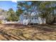 Charming home with a deck and a brick area in the front yard, surrounded by mature trees and landscaping at 301 Beaufort St, Summerville, SC 29483