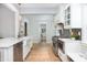 Bright kitchen features hardwood floors, white cabinetry, stainless steel appliances, and a tile backsplash at 301 Beaufort St, Summerville, SC 29483