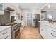Modern kitchen with stainless appliances, white cabinetry, and views to the dining and living areas at 301 Beaufort St, Summerville, SC 29483