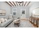 Comfortable living room showcasing a stylish gray sofa, decorative rug, and exposed beam ceiling at 301 Beaufort St, Summerville, SC 29483