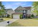 Charming two-story home featuring a manicured lawn, stone accents and a two-car garage at 330 Albrighton Way, Moncks Corner, SC 29461