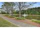 Scenic view of a tranquil pond with a fountain, surrounded by lush greenery and a paved walking path at 330 Albrighton Way, Moncks Corner, SC 29461