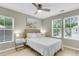 Bedroom with neutral walls, multiple windows, ceiling fan, bedside lamps, and a comfortable bed at 3844 Annapolis Way, Ladson, SC 29456
