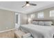 Bright bedroom with neutral walls and floor, windows, ceiling fan, large bed, and an ensuite bath at 3844 Annapolis Way, Ladson, SC 29456