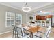 Open dining area boasts modern light fixture, seating for six, and a view of the spacious kitchen at 3844 Annapolis Way, Ladson, SC 29456