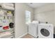 Well-organized laundry room with shelving, washer, dryer, and natural light at 3844 Annapolis Way, Ladson, SC 29456