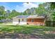 A brick home features solar panels and a grassy backyard with a small patio and wooden fence at 403 Forest Cir, Summerville, SC 29483