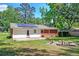 Brick and white siding of house with a firepit surrounded by log seats in the backyard at 403 Forest Cir, Summerville, SC 29483