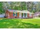 Charming brick home featuring a well-manicured lawn, green shutters, and a welcoming front porch at 403 Forest Cir, Summerville, SC 29483